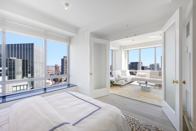 bedroom with light hardwood / wood-style flooring and multiple windows