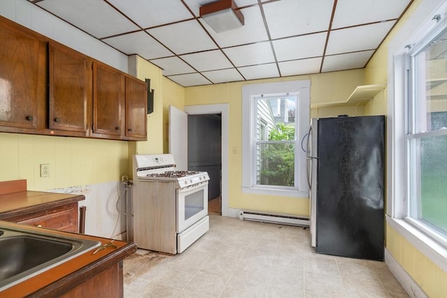 300-302 Main St, Gloucester, MA 01930 - kitchen featuring white gas range oven, freestanding refrigerator, a baseboard radiator, and healthy amount of natural light