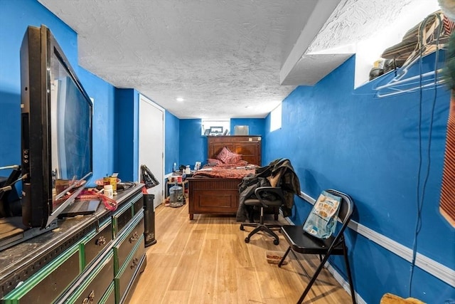 office space featuring a textured ceiling and light wood-type flooring