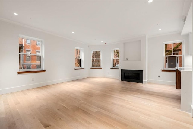 unfurnished living room with recessed lighting, a fireplace, baseboards, light wood finished floors, and crown molding