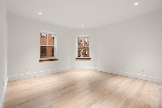 unfurnished room with baseboards, recessed lighting, and light wood-style floors