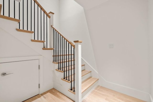 staircase featuring baseboards and wood finished floors