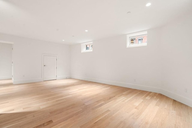 spare room featuring light wood-type flooring, baseboards, and recessed lighting