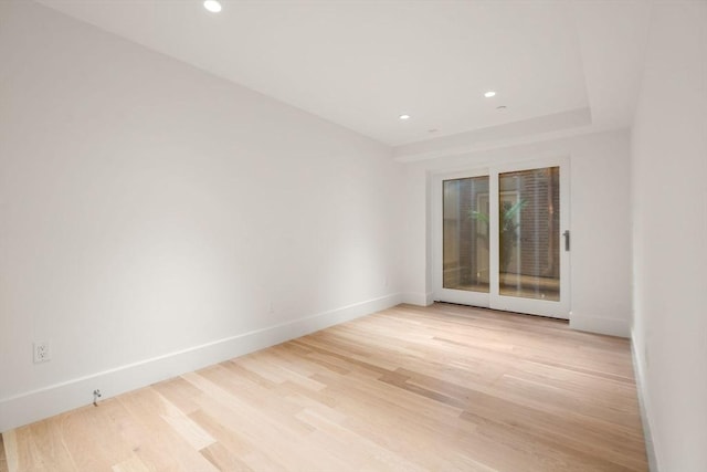 spare room with recessed lighting, light wood-type flooring, and baseboards