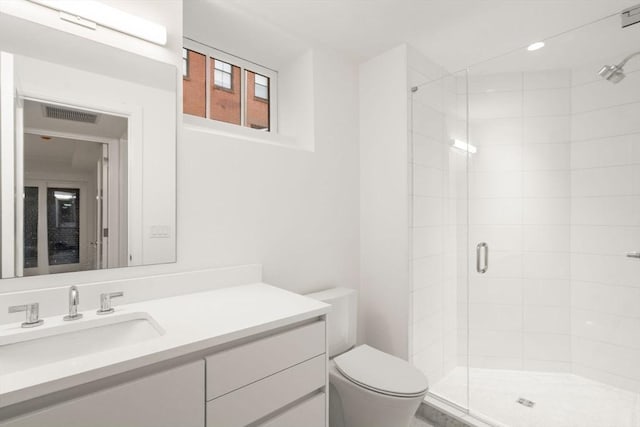 full bathroom featuring toilet, a shower stall, visible vents, and vanity