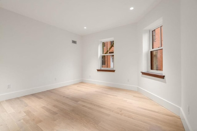 unfurnished room featuring light wood-style floors, recessed lighting, visible vents, and baseboards