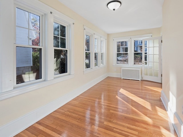 unfurnished sunroom featuring radiator heating unit