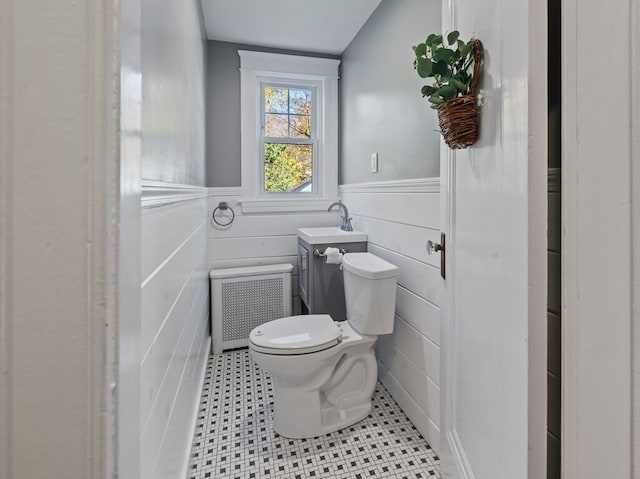 bathroom featuring radiator heating unit, vanity, toilet, and lofted ceiling