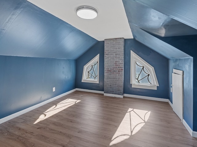 additional living space featuring hardwood / wood-style floors and vaulted ceiling