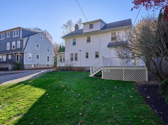 rear view of house featuring a lawn and a deck