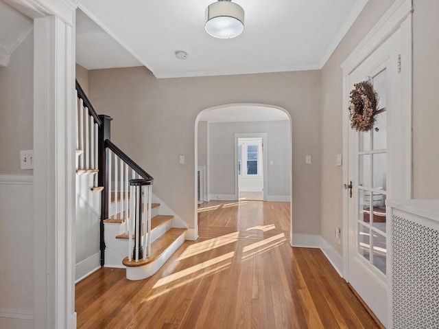 foyer entrance with ornamental molding and hardwood / wood-style flooring