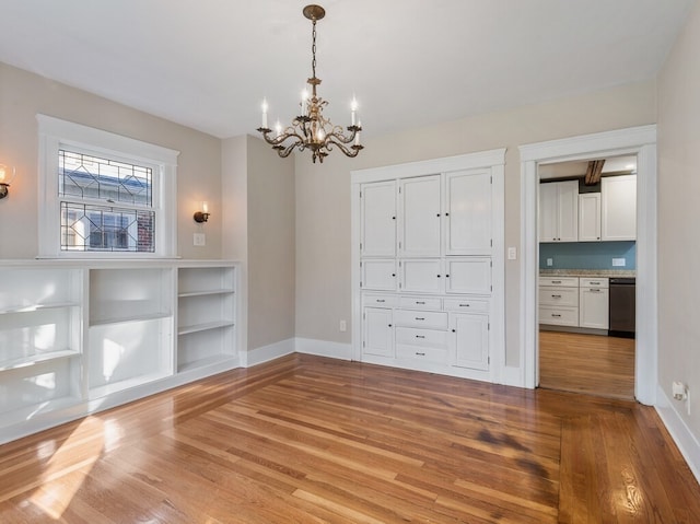 interior space with light hardwood / wood-style floors and an inviting chandelier