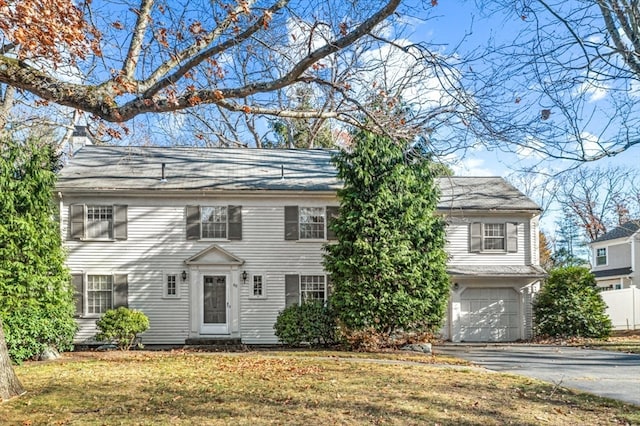 colonial home featuring a garage and a front yard