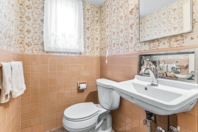 bathroom featuring toilet and tile walls