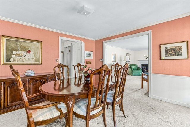 carpeted dining room featuring crown molding