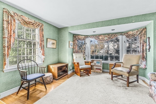 living area with hardwood / wood-style floors and a healthy amount of sunlight