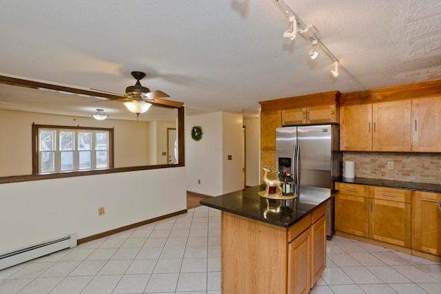 kitchen featuring tasteful backsplash, ceiling fan, a baseboard heating unit, light tile patterned floors, and a center island