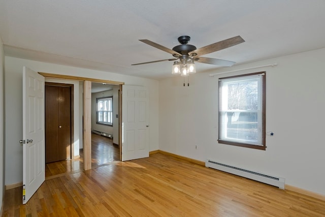 empty room featuring a baseboard radiator, light hardwood / wood-style flooring, and ceiling fan