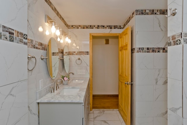 bathroom featuring vanity and tile walls