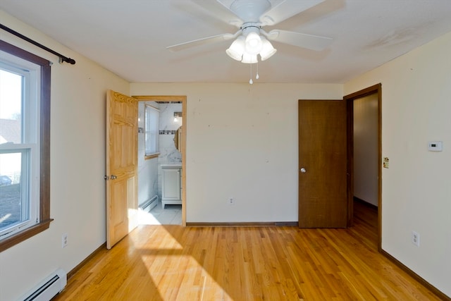 unfurnished bedroom with ceiling fan, ensuite bathroom, light wood-type flooring, and baseboard heating