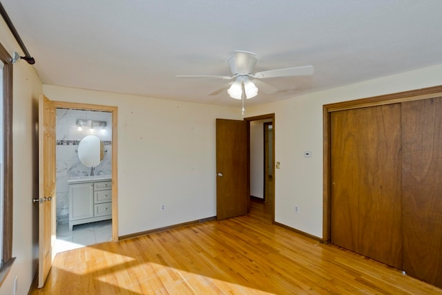 unfurnished bedroom with ensuite bath, ceiling fan, sink, light hardwood / wood-style floors, and a closet