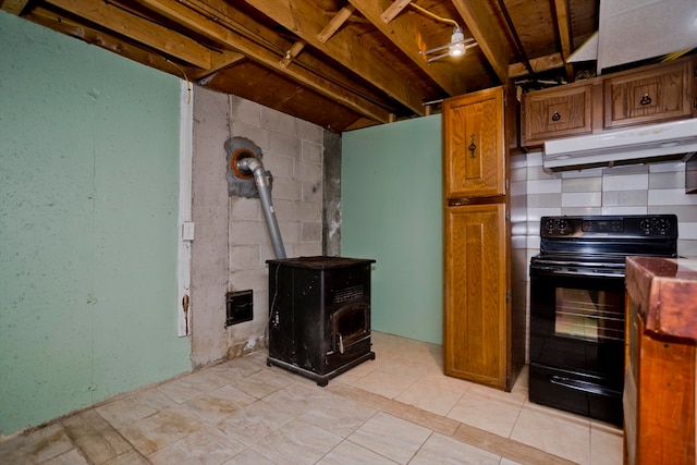 kitchen featuring light tile patterned floors, black range with electric cooktop, and a wood stove