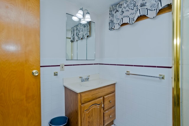 bathroom featuring vanity and tile walls