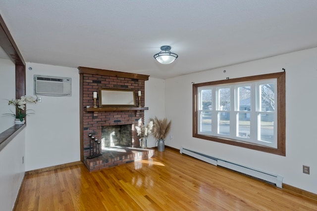 unfurnished living room featuring a wall mounted air conditioner, wood-type flooring, a brick fireplace, and a baseboard heating unit