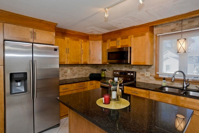 kitchen featuring a textured ceiling, decorative backsplash, sink, and stainless steel appliances