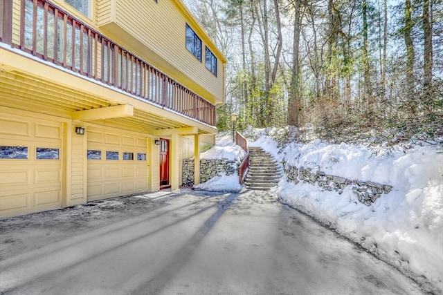 view of snowy exterior with an attached garage