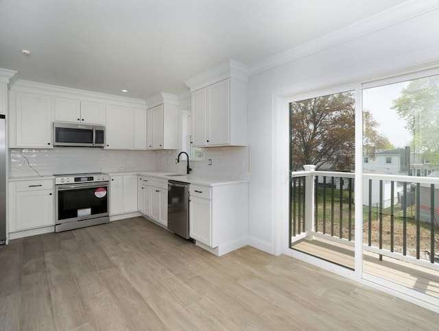 kitchen with a sink, light countertops, stainless steel appliances, and light wood-style flooring