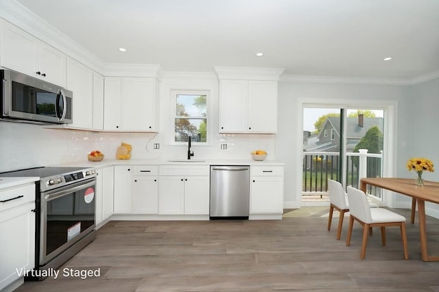 kitchen featuring light countertops, backsplash, appliances with stainless steel finishes, and a sink