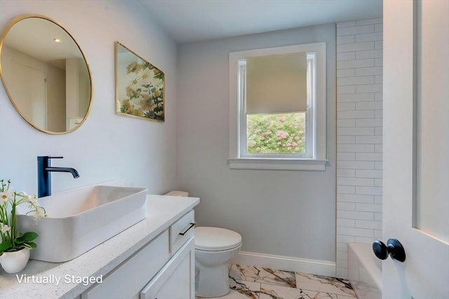 bathroom with vanity, baseboards, toilet, and marble finish floor