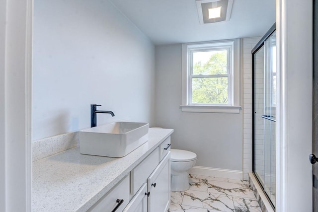 bathroom featuring vanity, marble finish floor, toilet, baseboards, and a stall shower