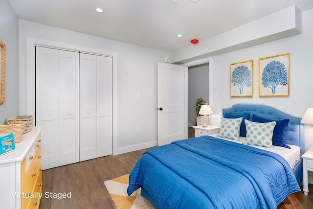 bedroom with baseboards, a closet, recessed lighting, and wood finished floors