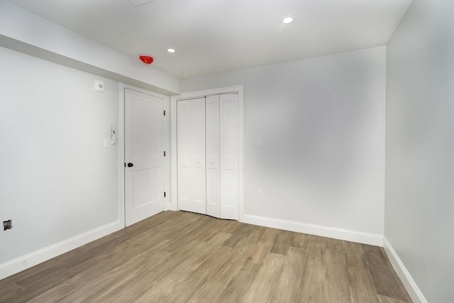spare room with recessed lighting, baseboards, and light wood-type flooring
