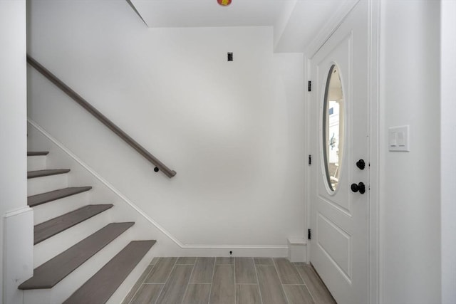 foyer entrance featuring baseboards and stairway