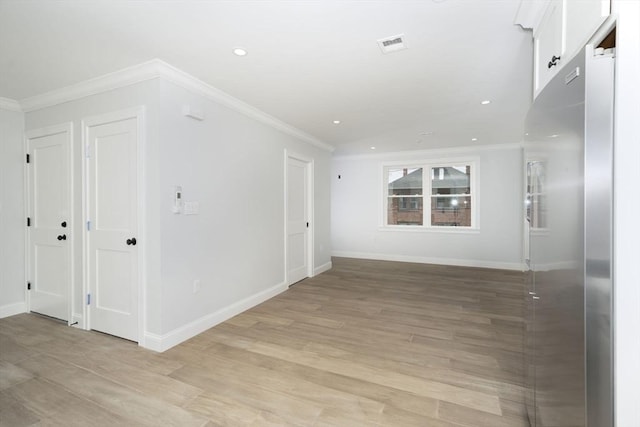 spare room with visible vents, baseboards, light wood-style floors, ornamental molding, and recessed lighting