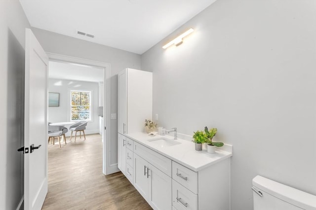 bathroom with vanity, hardwood / wood-style floors, and toilet