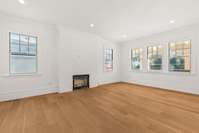 unfurnished living room featuring ornamental molding and light hardwood / wood-style floors