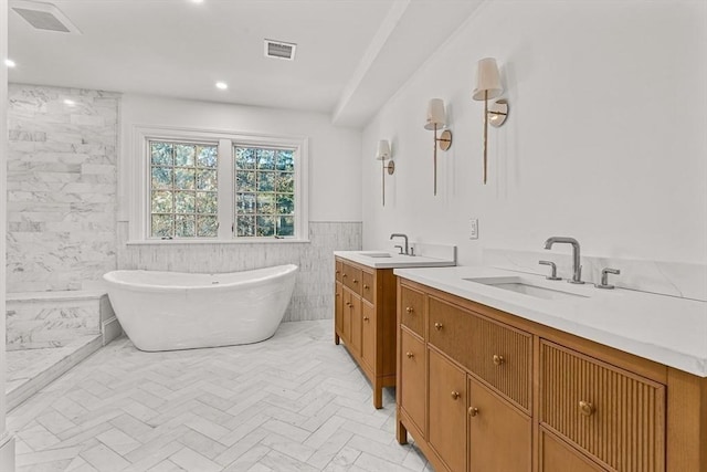 bathroom with vanity, a tub, and tile walls