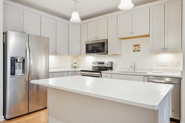 kitchen featuring hanging light fixtures, a center island, sink, and appliances with stainless steel finishes