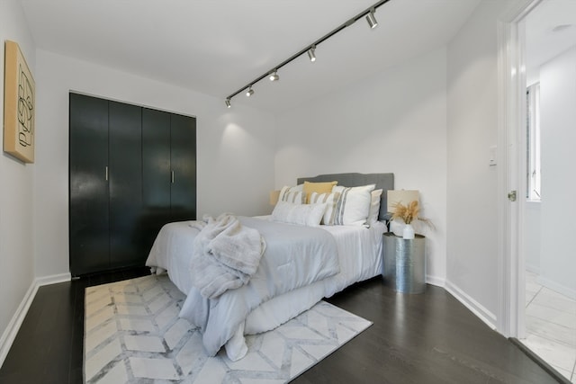 bedroom featuring dark hardwood / wood-style floors and rail lighting