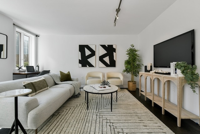 living room with rail lighting and dark hardwood / wood-style flooring