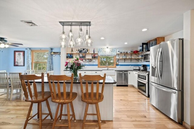 11 Michael Rd, Bourne, MA 02559 - kitchen featuring open shelves, appliances with stainless steel finishes, white cabinetry, visible vents, and a kitchen island