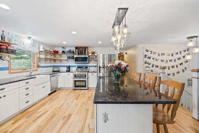 11 Michael Rd, Bourne, MA 02559 - kitchen featuring dark stone countertops, open shelves, a sink, light wood-style flooring, and appliances with stainless steel finishes