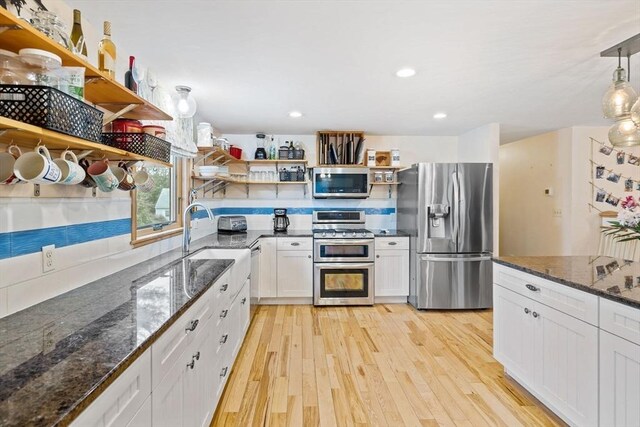 11 Michael Rd, Bourne, MA 02559 - kitchen featuring dark stone counters, light wood-type flooring, white cabinetry, open shelves, and appliances with stainless steel finishes