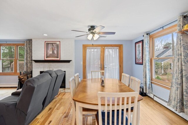 11 Michael Rd, Bourne, MA 02559 - dining room featuring a baseboard radiator, a fireplace, ceiling fan, and light wood-type flooring