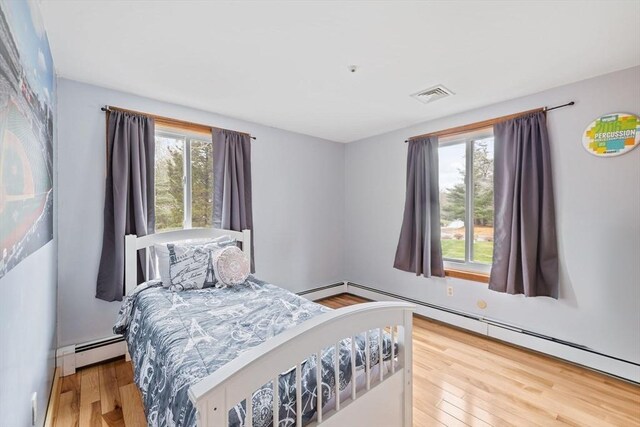 11 Michael Rd, Bourne, MA 02559 - bedroom with wood finished floors, visible vents, and a baseboard radiator
