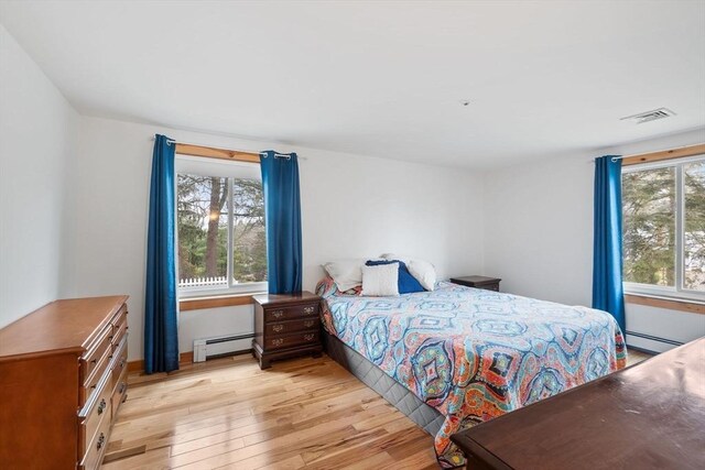 11 Michael Rd, Bourne, MA 02559 - bedroom featuring a baseboard heating unit, light wood-style floors, and visible vents
